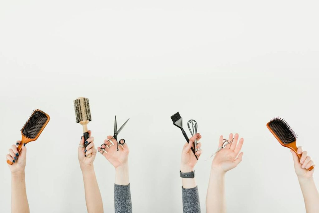 Hands in the air showing hair dressing supplies and talents.